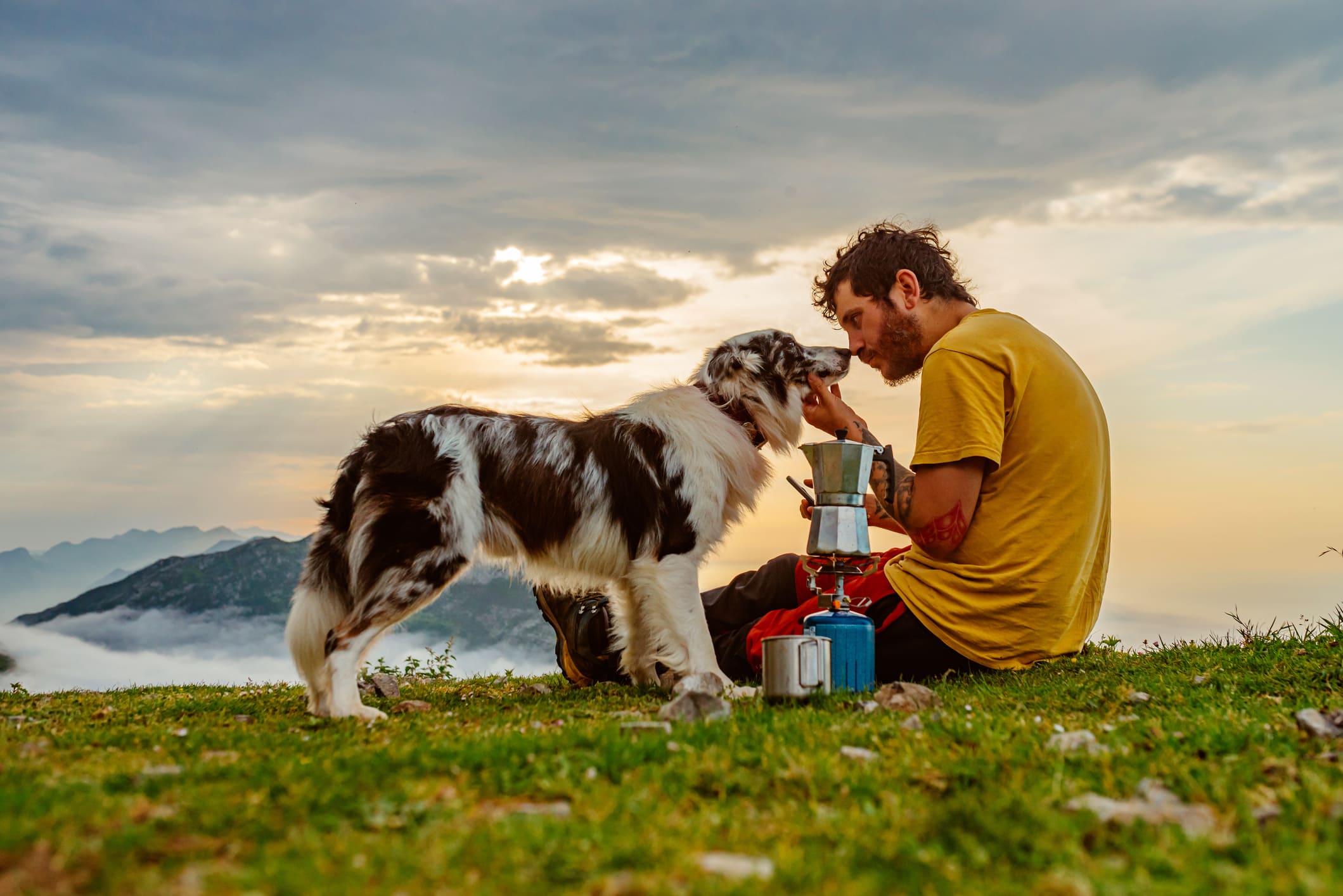 Un jeune homme en compagnie de son chien, face à face, partageant un moment de complicité avant le travail.